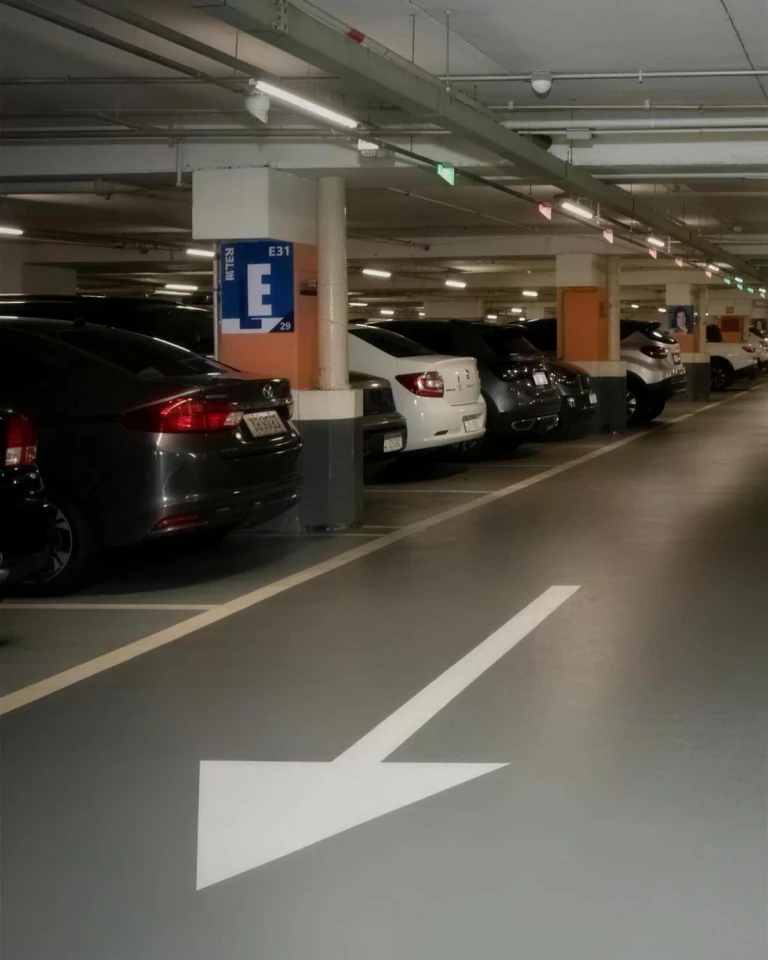 Estacionamento coberto no subsolo do edifício, com vagas sinalizadas