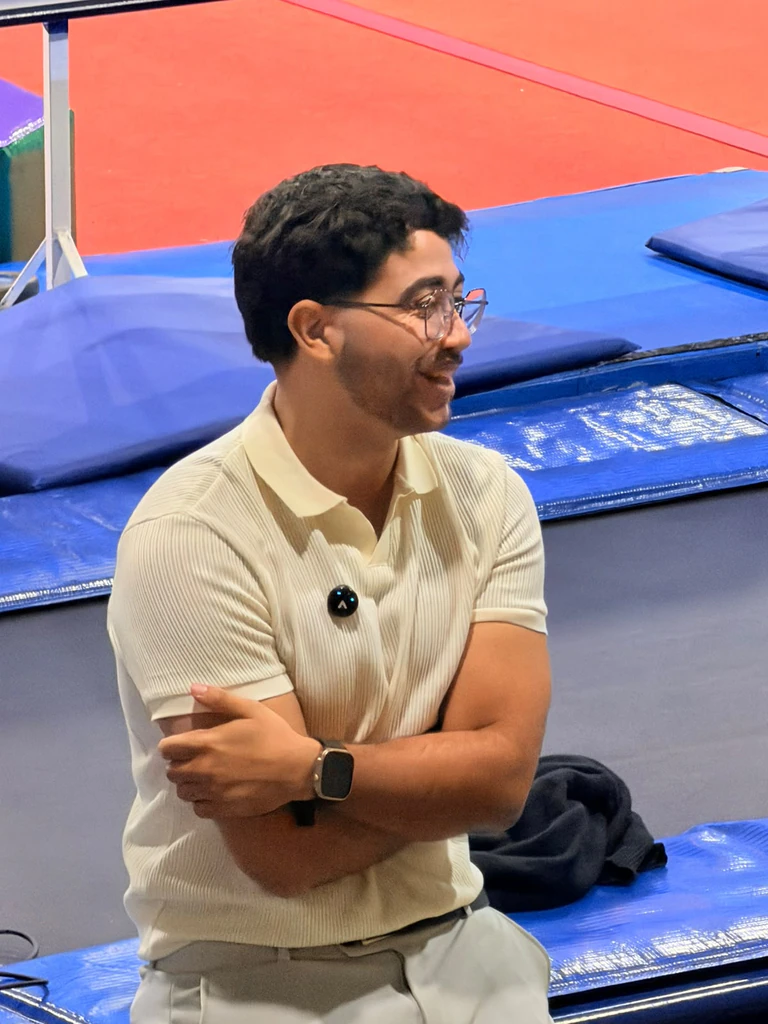 Luiz Macedo de óculos e camisa clara em um ambiente esportivo