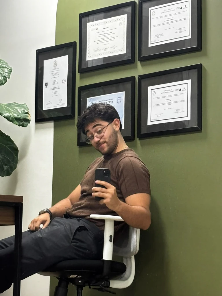 Luiz Macedo sentado no consultório, diante da parede com certificados