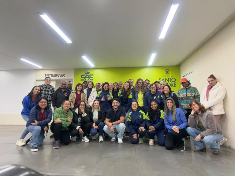 Foto de grupo dos participantes da palestra com Luiz Macedo ao centro, diante da parede da Prefeitura de Santo André
